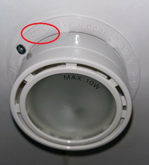 Vit plast lampa sockel utan glödlampa, text och symboler, röd cirkel markerar en detalj. Max 10W.