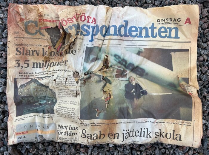 Nött, trasig svensk tidning, "Korrespondenten", datum 22 december 1993, ligger på marken.
