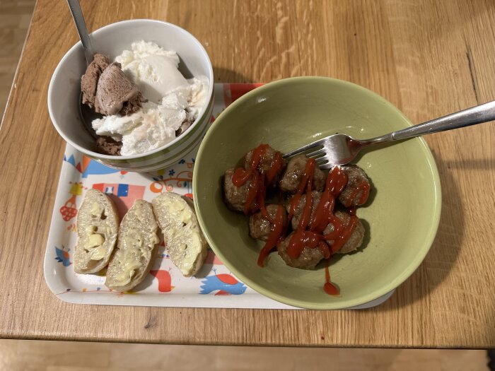 Middag och dessert: köttbullar med ketchup, smörade baguettebitar, glass med choklad och vaniljsmak i skål.