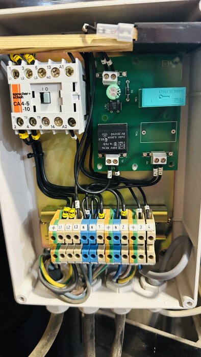 Elektrisk kopplingsdosa med kontaktorer, anslutningar, kablar. Industriella komponenter för strömfördelning eller styrning.