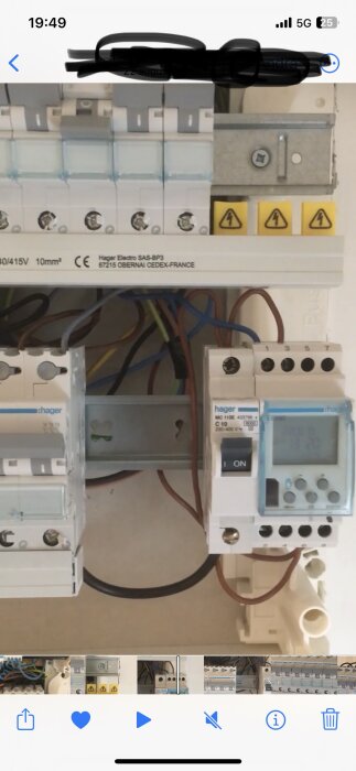 Elektriskt säkerhetsbrytare och säkringsskåp med ledningar och varningsmärken, installationsutrustning, elektrikerarbete.