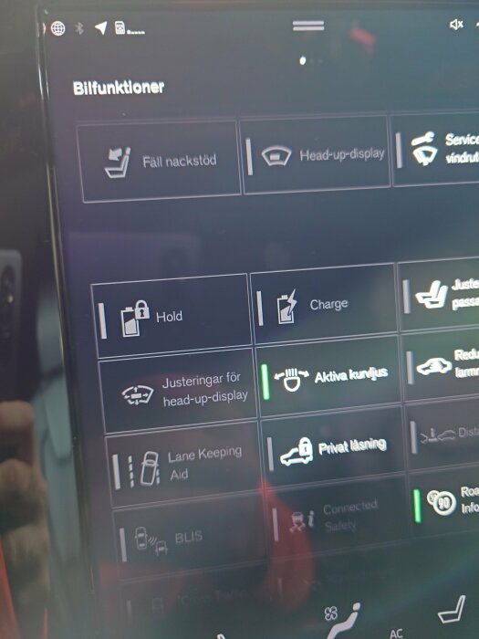 Bild av en bilskärm som visar olika fordonsfunktioner som head-up-display och Lane Keeping Aid.