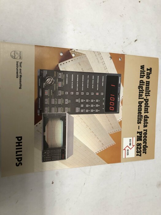 Gammal Philips mätinstrumentmanual, röd digital skärm, pappersbakgrund, datalogger, PM 8287 modell.