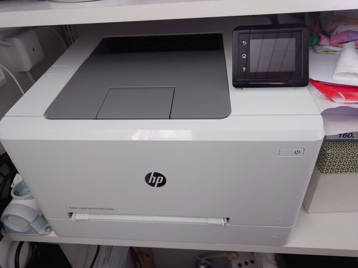 HP Color LaserJet Pro M255dw skrivare på skrivbord, touchskärm, pappersutmatningsfack, vit, modern.