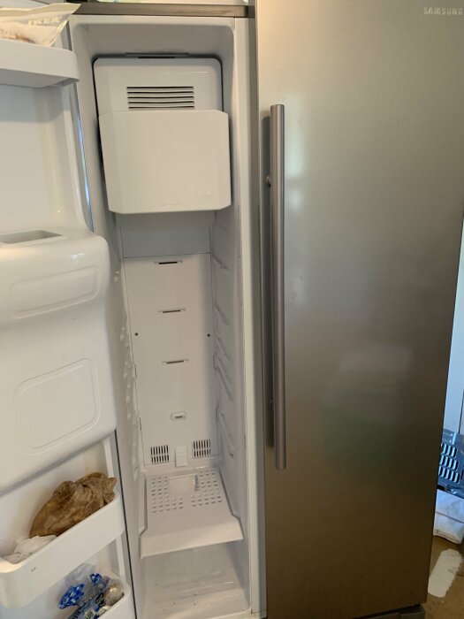 Öppet, tomt kylskåp från Samsung med dörren till höger.