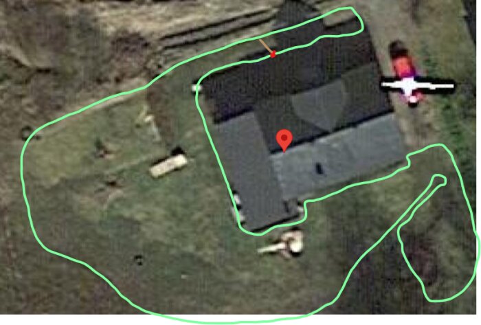 Flygbild över en fastighet med hus och markerade gränser. Objekt likt en häst syns.