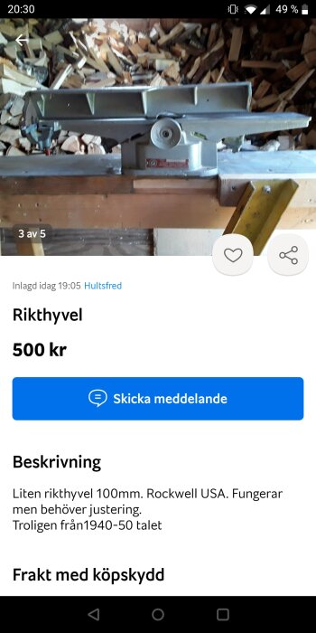 En rikthyvel, troligen gammal, för försäljning. Bakgrund: staplade vedträn. Text ger info om pris och funktion.