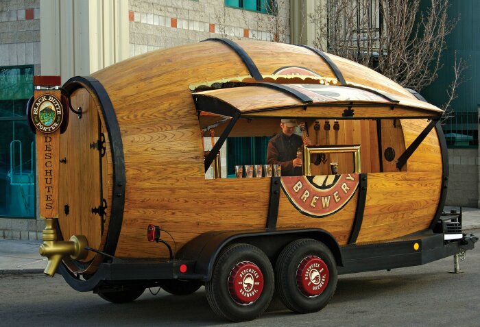 Mobil bar formad som fat, med kran och Deschutes Brewery-logotyp, på hjul utomhus.