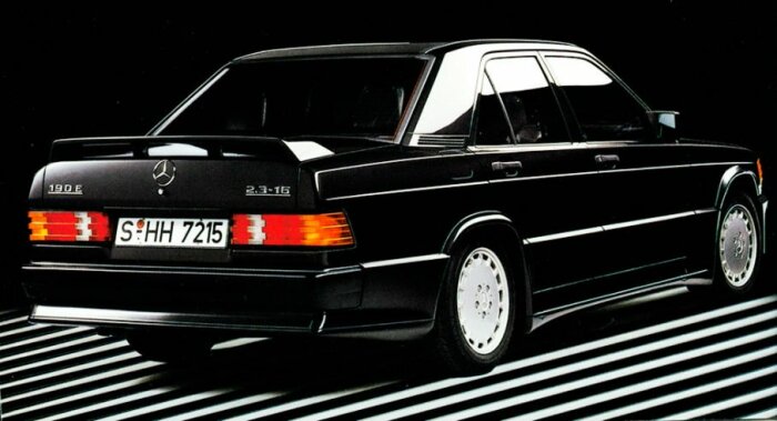 Svart Mercedes-Benz 190E 2.3-16, klassisk design, bakifrån, kontrasterande vita ränder på svart bakgrund.