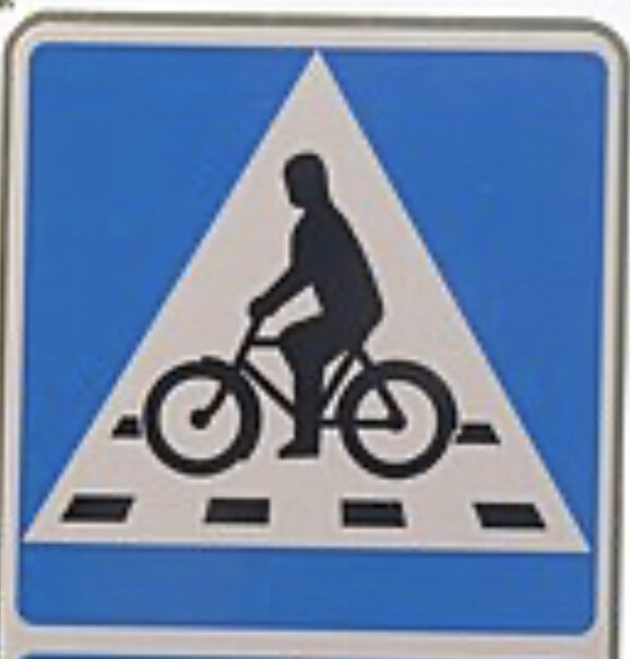 Trafikskylt, blå bakgrund, vit och svart cyklist, övergångsställe, varningsikonen, fyrkantig form.