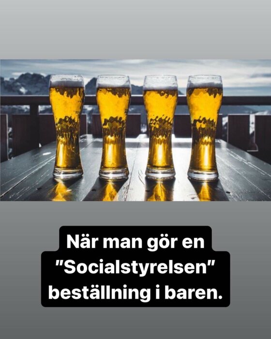 Fyra ölglas på ett bord, molnig himmel i bakgrunden, text skämt om "Socialstyrelsen" beställning.