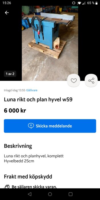 Blå stationär hyvelmaskin på pall, säljes online, verkstad i bakgrund, skärmdump från en mobil.