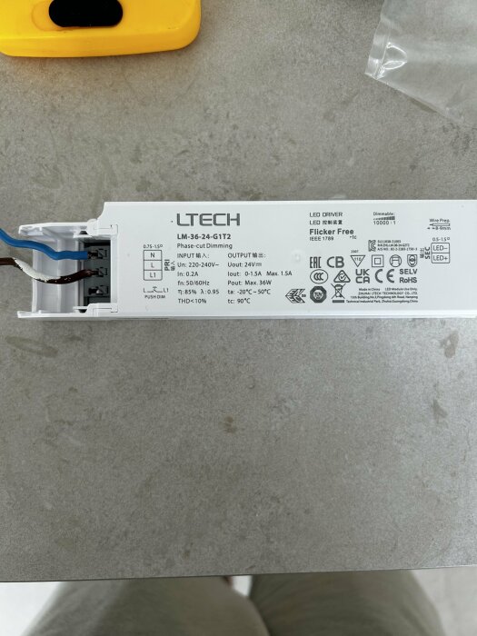 En LED-drivare av märket LTECH med specifikationsetikett och delvis ansluten kabelsynlighet.