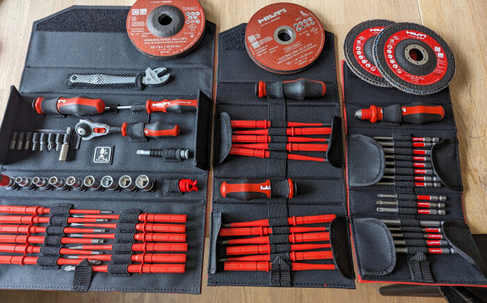 Verktygsväska öppen med ordnade verktyg: skruvmejslar, hylsor, skiftnyckel, bits och slipdiskar.