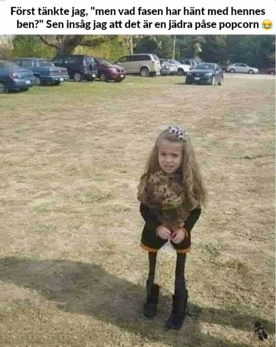 Flicka står med popcornpåse, skapar illusion av genomskinliga ben. Parkering i bakgrunden, visuell förbistring.