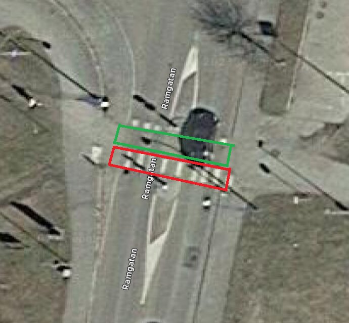 Flygbild av en gata med ett övergångsställe och skuggor från gatlyktor.