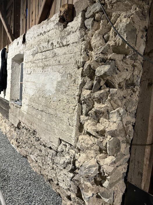Delvis demoleras stenmur med synliga kablar, kontrast av konstruktion och förfall, inomhus.