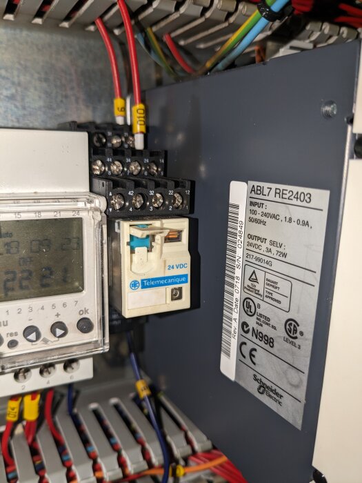 Elektriskt kapslingskåp med terminaler, kablar, och en omvandlare märkt Schneider Electric, samt kontrollhårdvara.