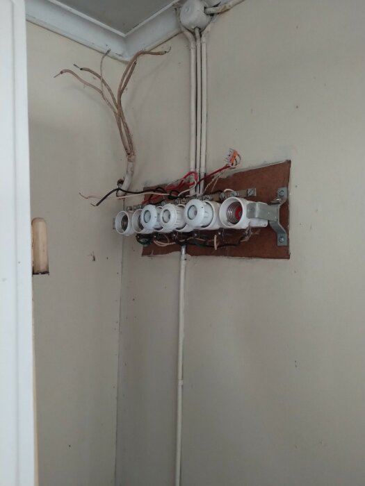 Omonterade eluttag och exponerade elektriska kablar på en vägg. Renovering eller reparation kan vara pågående.