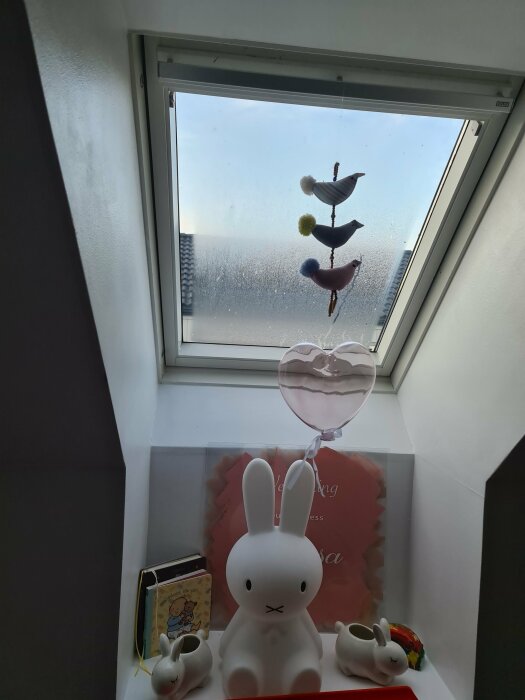 Regnigt fönster, färgglada tygfåglar, Miffy-lampa, böcker, prydnadssaker, inomhusdekoration, mysigt, barnkammarelement.