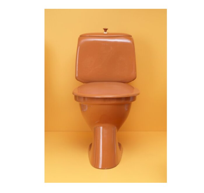 Brun toalettstol mot gul bakgrund, enfärgad, minimalistisk, isolerad, keramik, badrumsinredning.