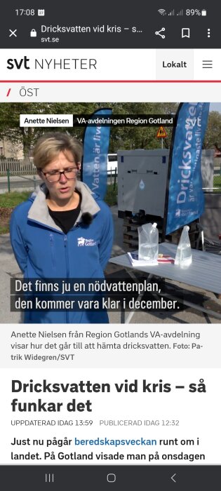 Kvinna intervjuas om nödvattenplan, Gotland. Mobilskärm, nyhetsartikel, vattenutdelningsstation och flaggor syns.