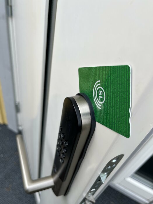 Grönt bankkort kilat mellan dörr och lås, försök till olåsning.