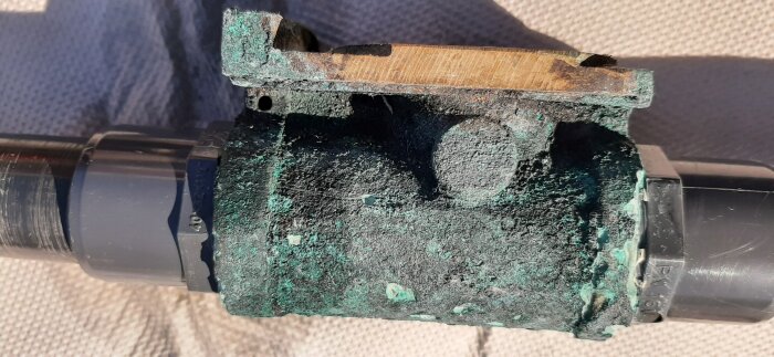 Kopparrör med gröna korrosionsprodukter, gammalt vattenläckage, möjlig rörförstörelse, behov av reparation.