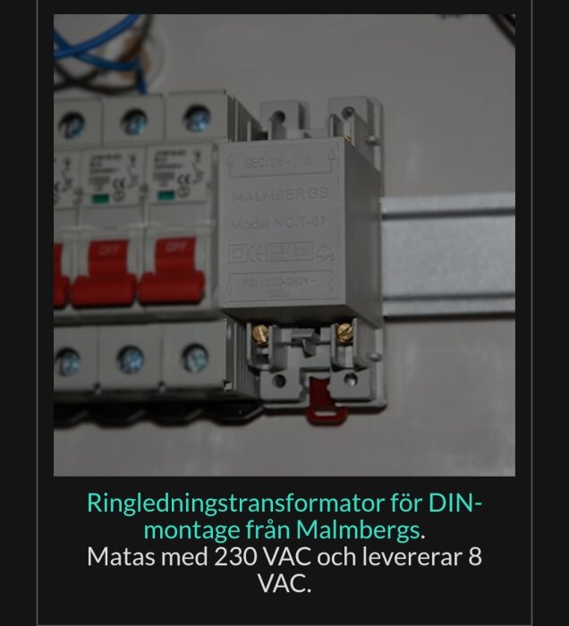 Elektrisk installation av ringledningstransformator på DIN-skena, grå, med röda säkringsbrytare, elskåp.