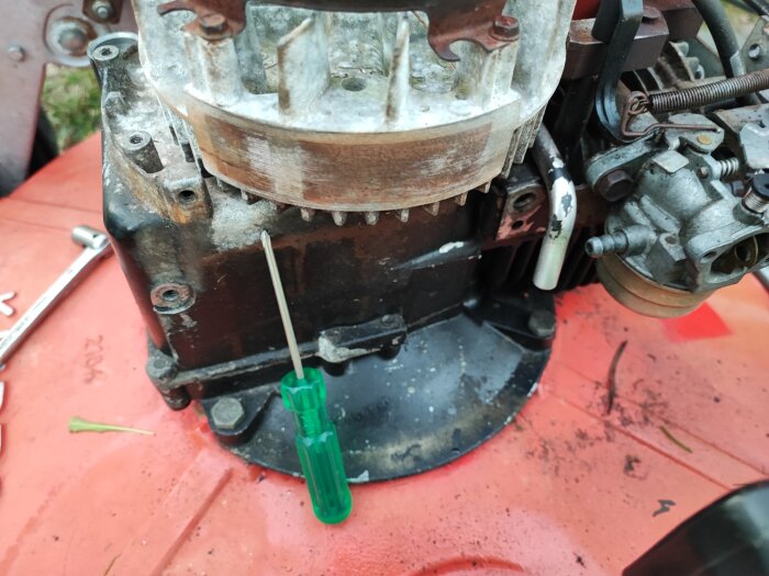Motor, verktyg, grön skruvmejsel, rost, reparation, maskindelar, smutsig röd yta.
