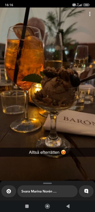 Efterrätt med glass och bär, drink med apelsinskiva, mysig atmosfär, middag, glädje.