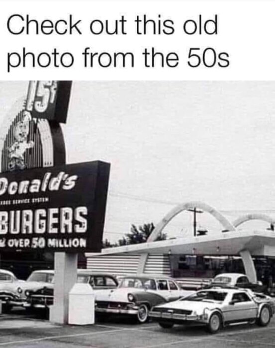 Svartvit bild, McDonald's från 1950-talet, äldre bilar, retro arkitektur, stor skylt, "över 50 miljoner" hamburgare.