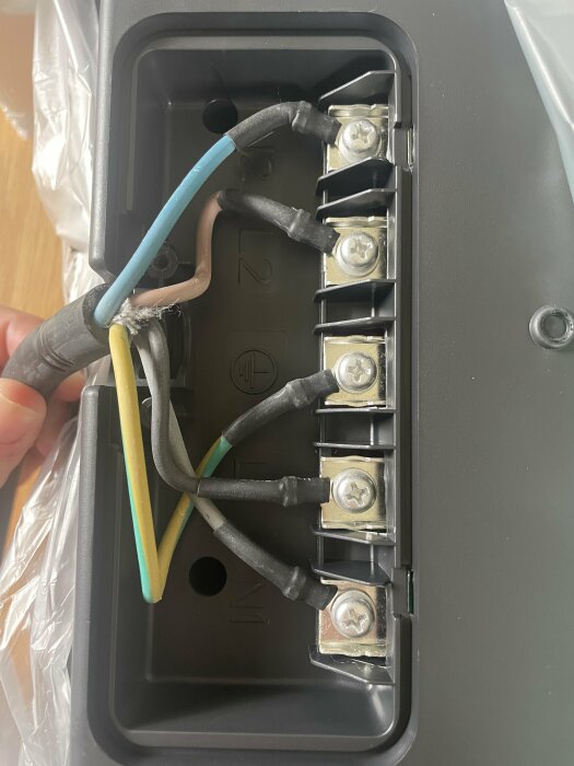 Elektrisk anslutningsbox med ledningar och anslutningsklemmor, installationsprocess, öppet lock.