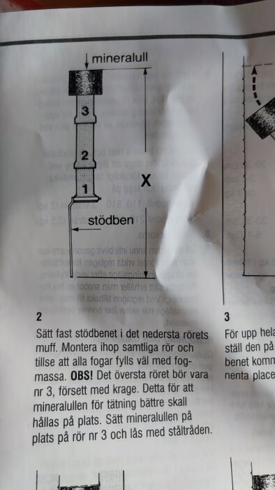 Instruktionsblad med diagram av rörledning, text på svenska, skrynklat papper i hörnet.