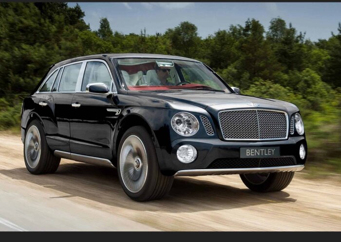 Svart Bentley SUV kör på landsväg, förare synlig, lyxig, modern design.