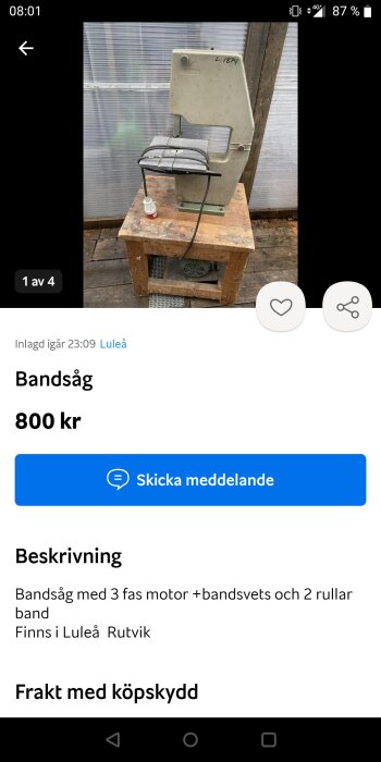 Bandsåg till salu, grå, begagnad, står på träpall, inomhus, bakgrund av vågigt plåt, prisangivelse, plats Luleå Rutvik.