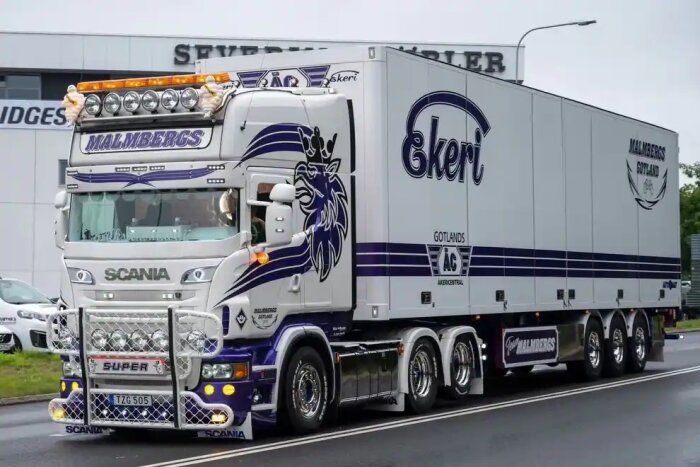 Vit och blå lastbil, dekorerad, Scania, släp, "Malmbergs", kromdetaljer, extra lampor, på vägen.