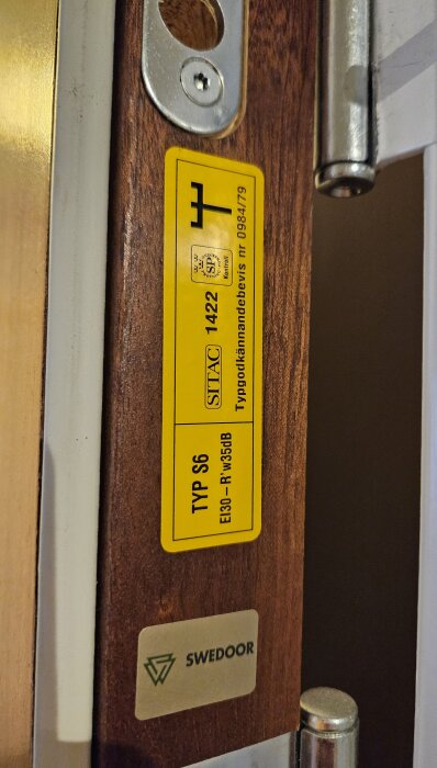 Dörrkarm med säkerhetscertifieringsetikett, märkning för brandmotstånd, lås och gångjärn, tillverkad av Swedoor.