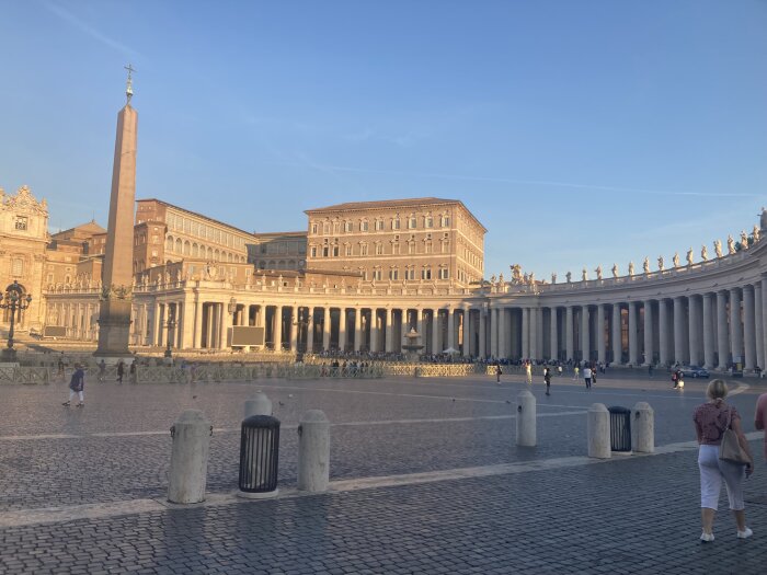 Petersplatsen i Vatikanstaten, obelisk, kolonnader, historisk arkitektur, turister, klar himmel, eftermiddagsljus.