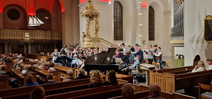 Kör framför, pianist och dirigent, i kyrka, publik lyssnar, traditionell dräkt, interiör, konserterande.