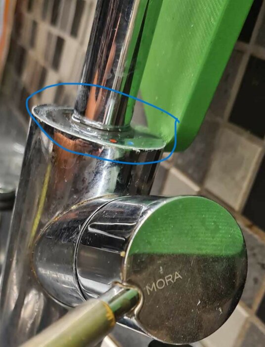 Kökskran med droppande vatten, kalkavlagringar, blå cirklar markerar avlagringar, grönt handtag, märke synligt.