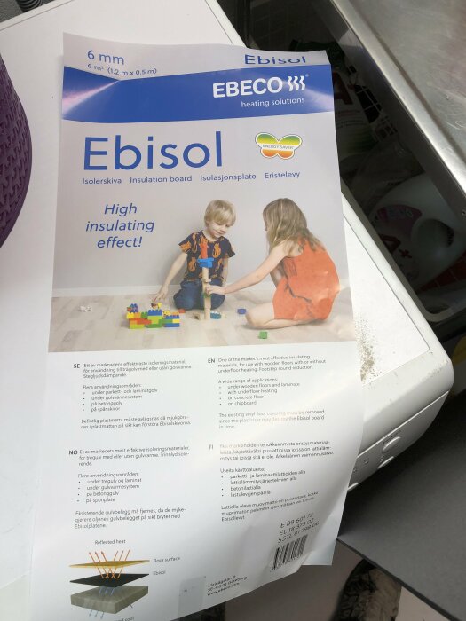 Produktblad för Ebisol isoleringsskiva, två barn leker på golvet, information om användning och egenskaper.