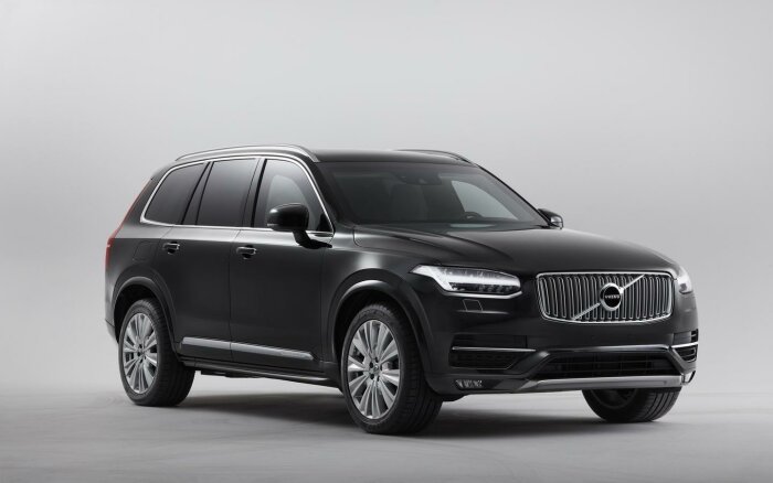 Svart SUV, Volvo XC90, framifrån, elegant design, grå bakgrund, studiobelysning, rena linjer, skandinavisk stil.