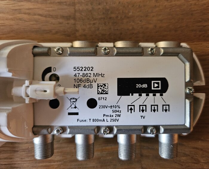 Elektronikkomponent, troligen signalbooster, med tekniska specifikationer och anslutningsportar synliga.