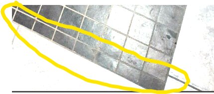 Bild av golv med kakel, överlagrat med en gul markering eller teckning, ljus bakgrund, perspektiv snett uppifrån.