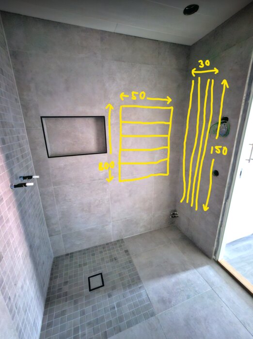 Badrum under renovering med märkningar för installation, kakel, duschränna och förberedelser för värmeelement.