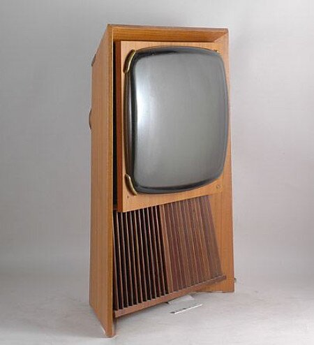 Gammal TV i träskåp, stor, rundad gråskala skärm, retro design, 1950-talet, stående, ribbade paneler, vintage elektronik.