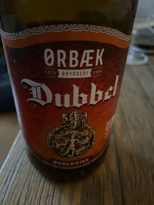 Ölflaska från Ørbæk Bryggeri, Dubbel, ekologisk, datum okänt, etablerad 1906, mönster och vapensköld motiv.