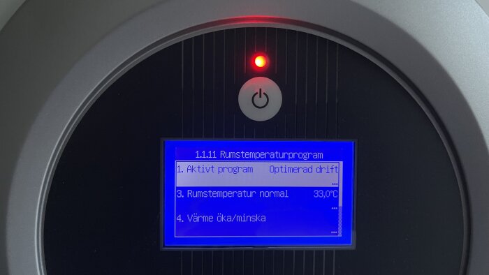 Digital display med rumstemperaturkontroll, menyval, 33 grader Celsius, röd strömindikator, svart och grått hölje.