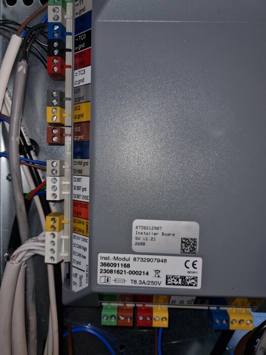 Elektrisk anslutningspanel med etiketterade kablar, terminaler, säkringar och identifieringsetiketter. Industriell komponent.